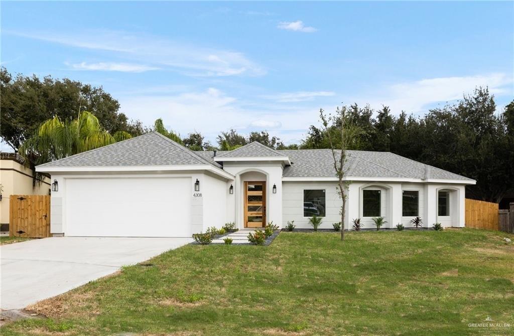 Single story home featuring a garage and a front lawn