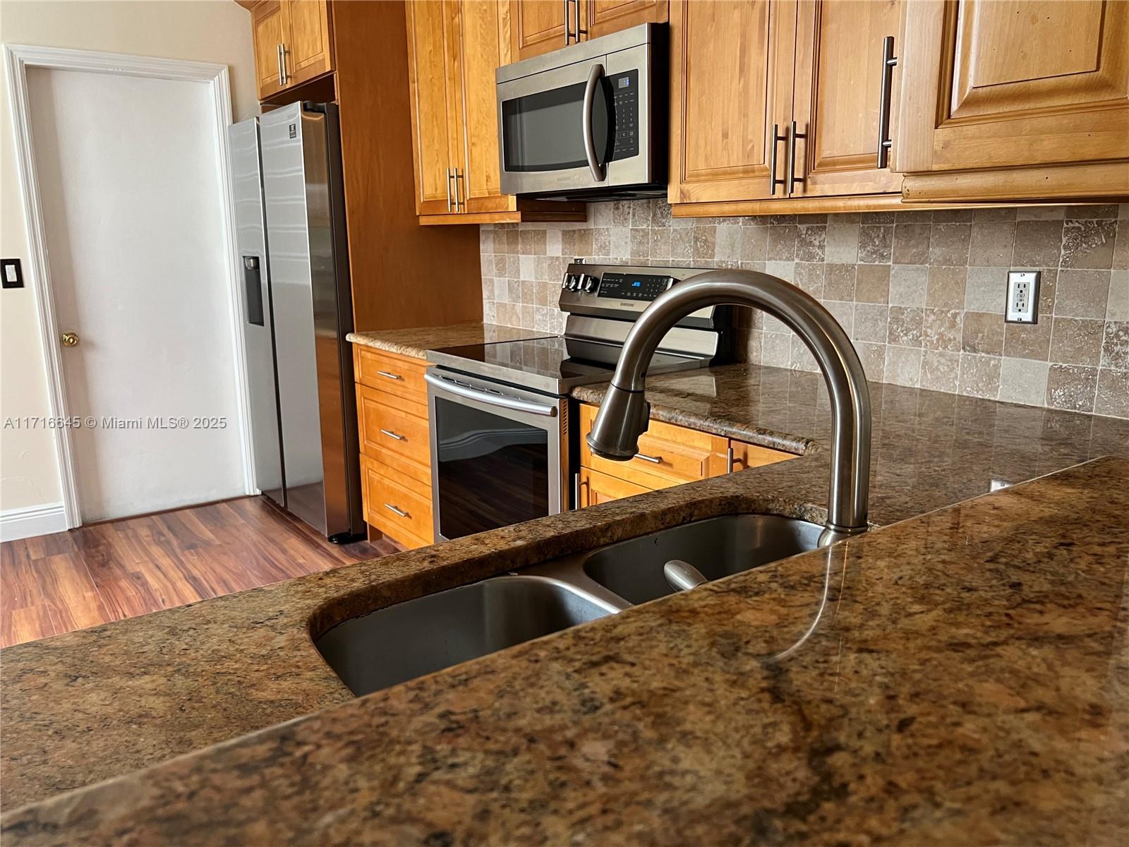 a kitchen with stainless steel appliances a stove a microwave and cabinets