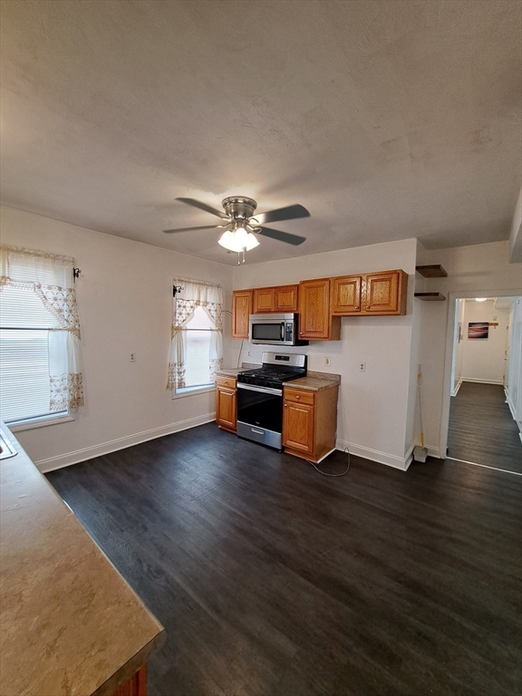 a view of a livingroom with furniture wooden floor and a ceiling fan