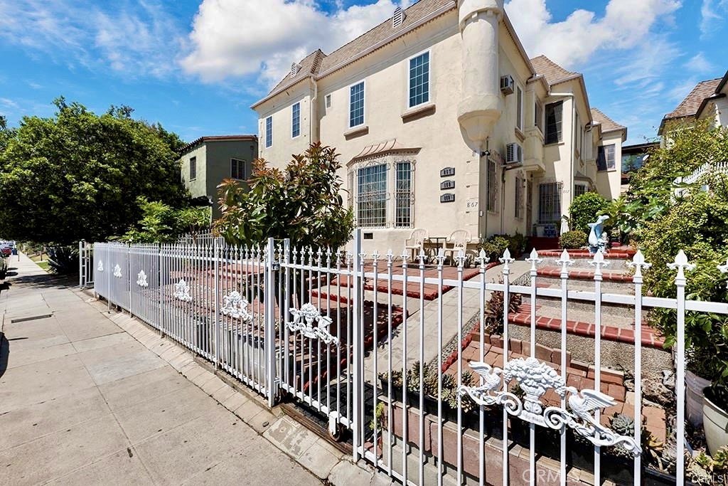 a view of a white building with wooden fence