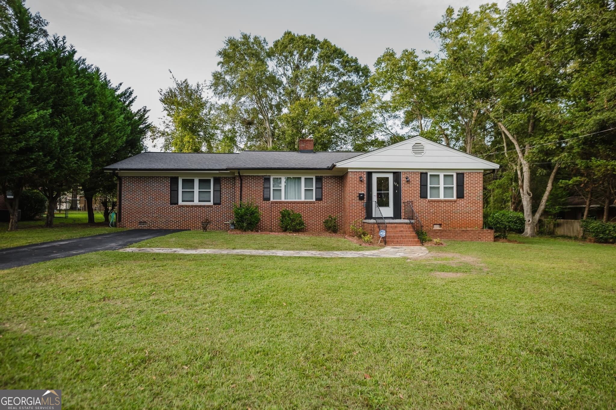 a front view of a house with a garden