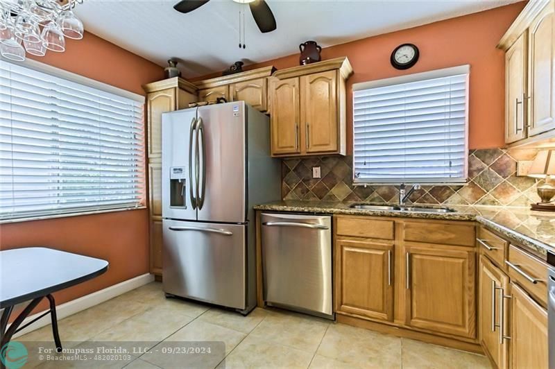 a kitchen with stainless steel appliances granite countertop a refrigerator and a sink