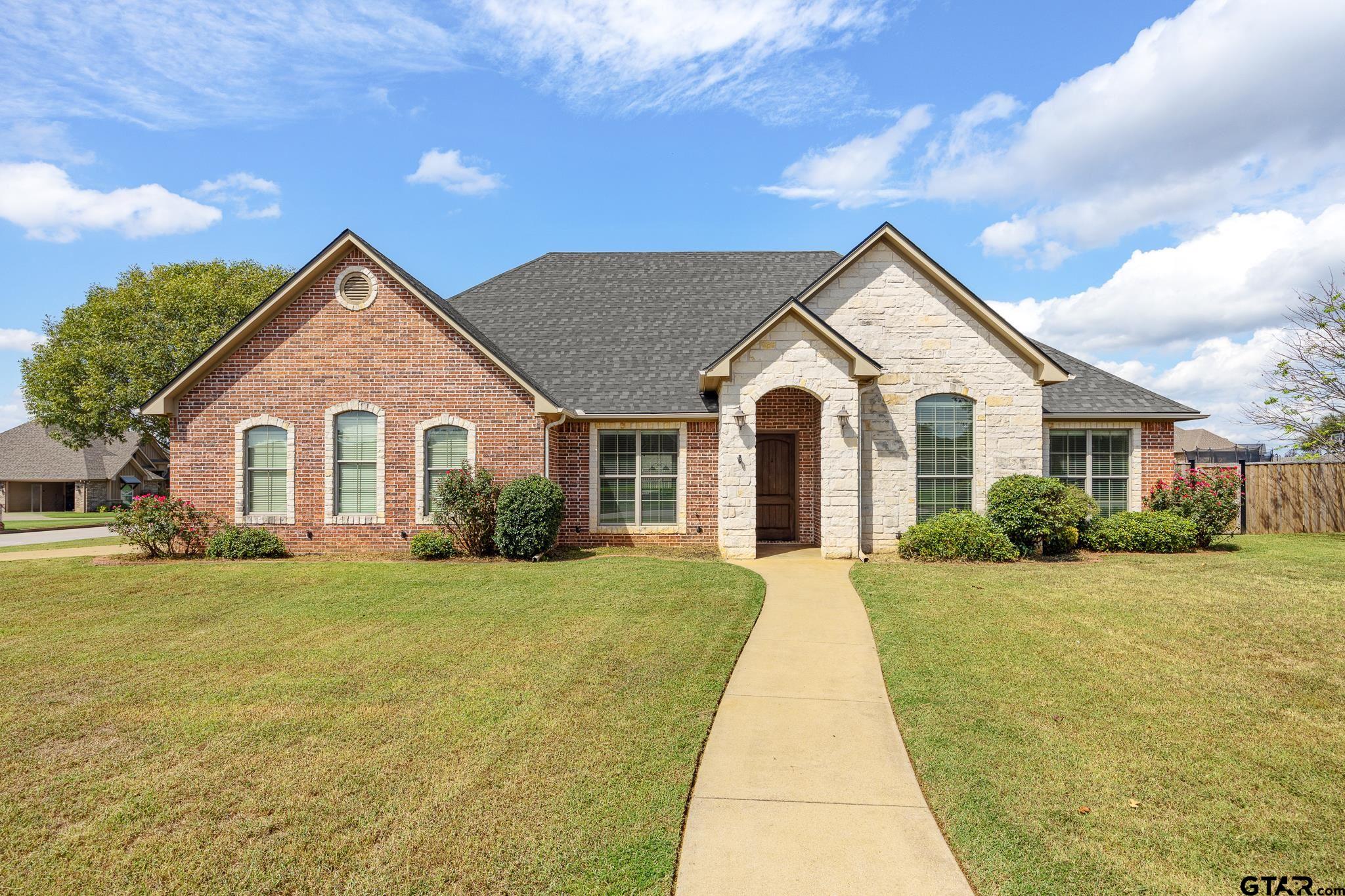 a view of a house with a yard and fence