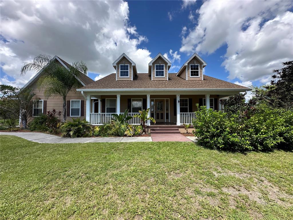 a front view of a house with swimming pool and porch