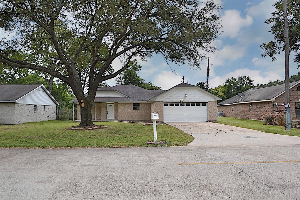 front view of house with a yard and trees