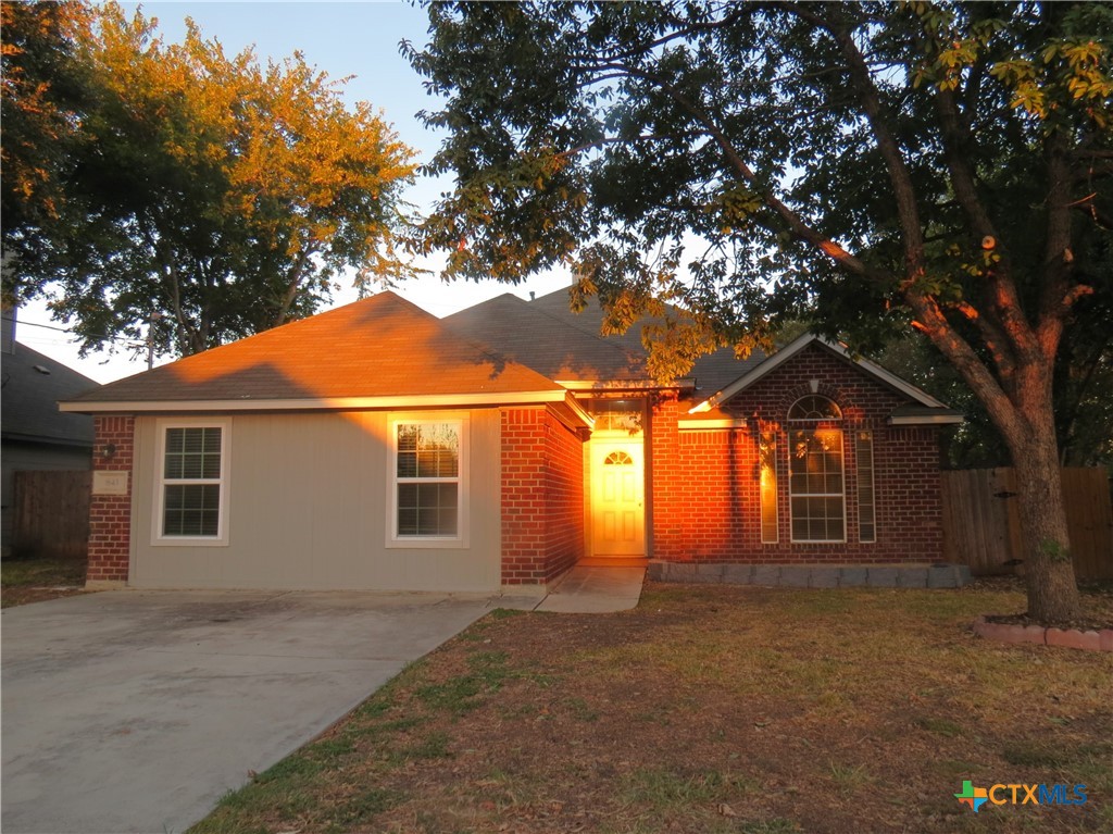 a front view of house with yard and trees