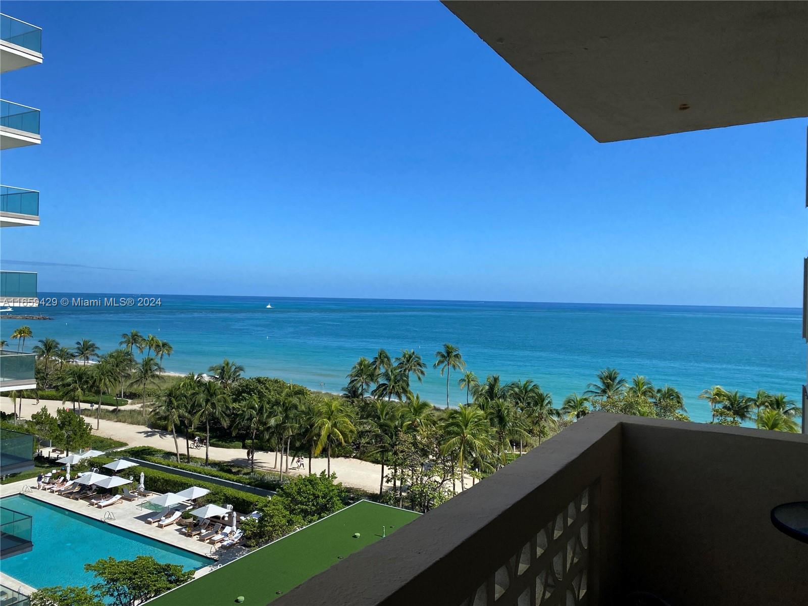 an aerial view of ocean and residential houses with outdoor space