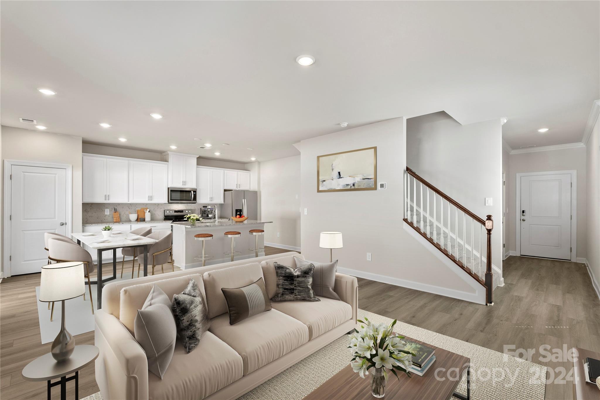 a living room with furniture kitchen view and a wooden floor