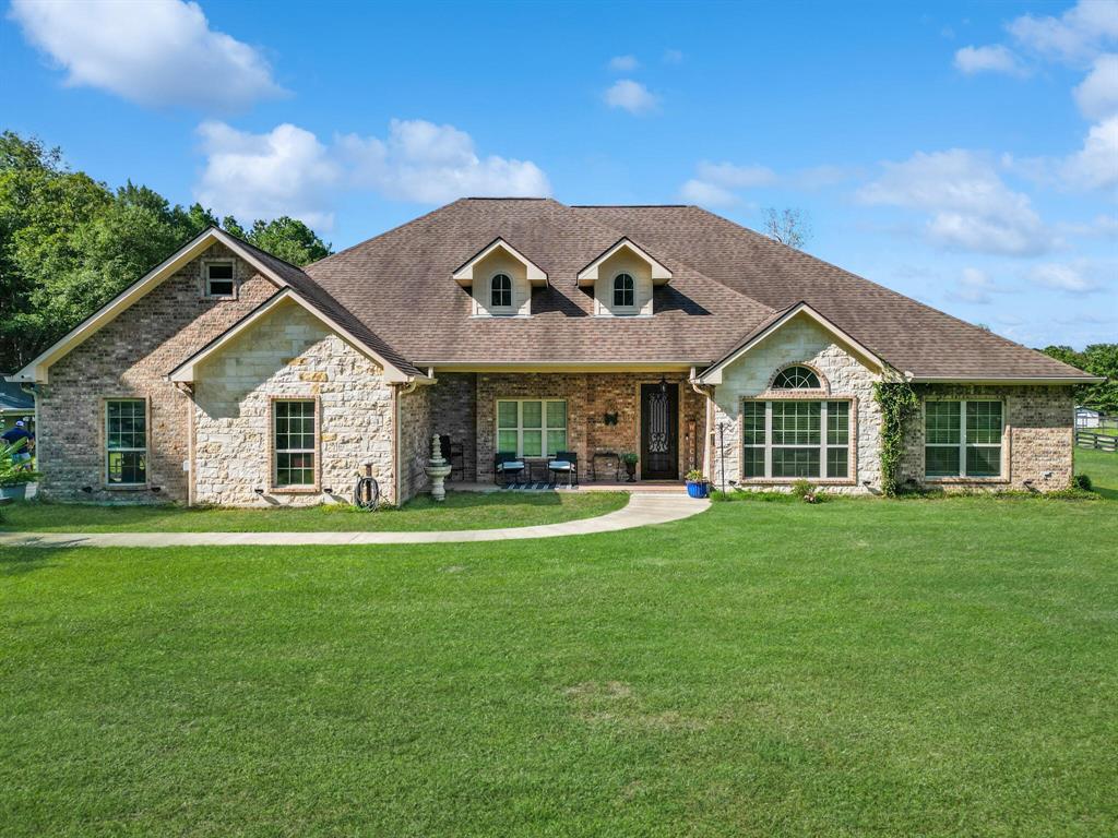 a front view of a house with a garden