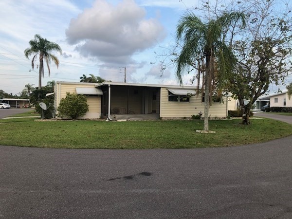 a front view of a house with a garden and tree