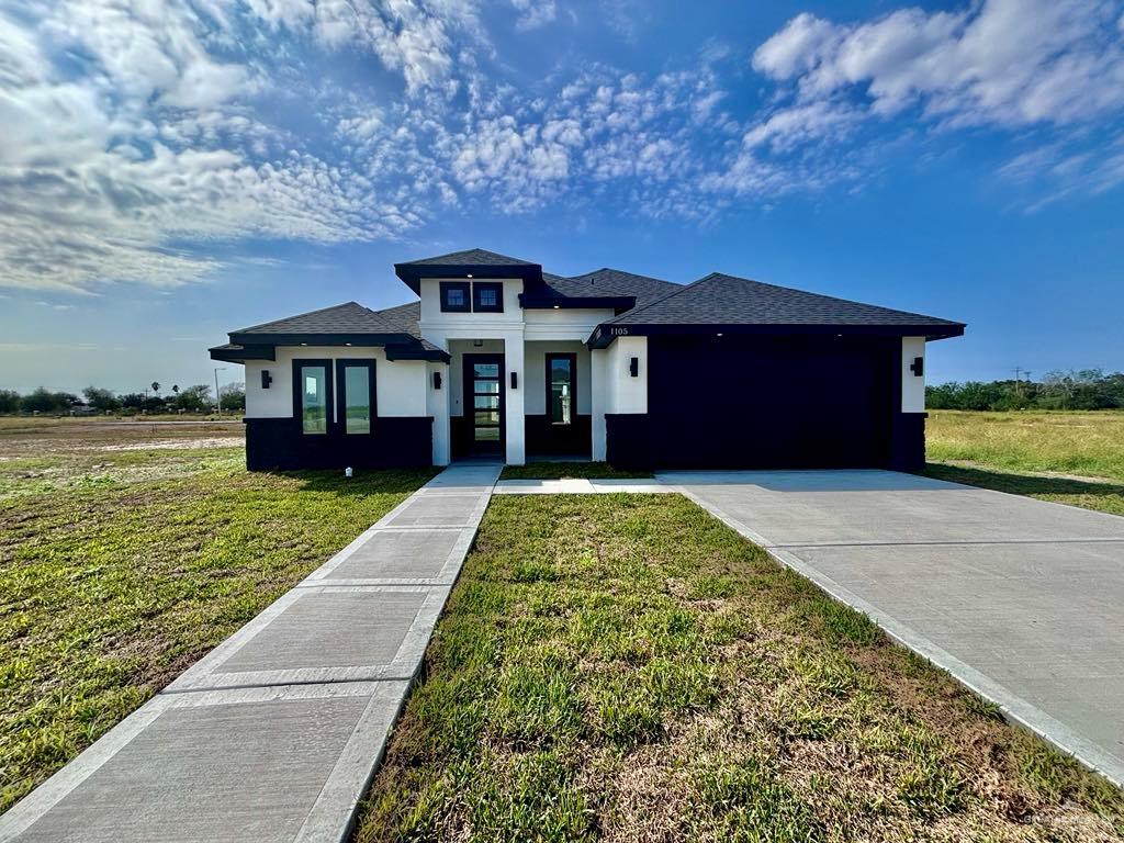 Prairie-style house with a garage and a front yard