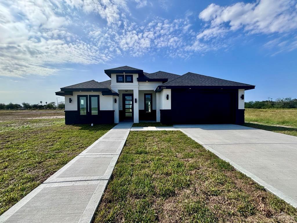 Prairie-style house with a garage and a front yard