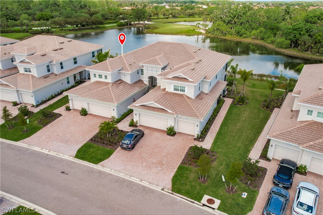 an aerial view of house with outdoor space and lake view