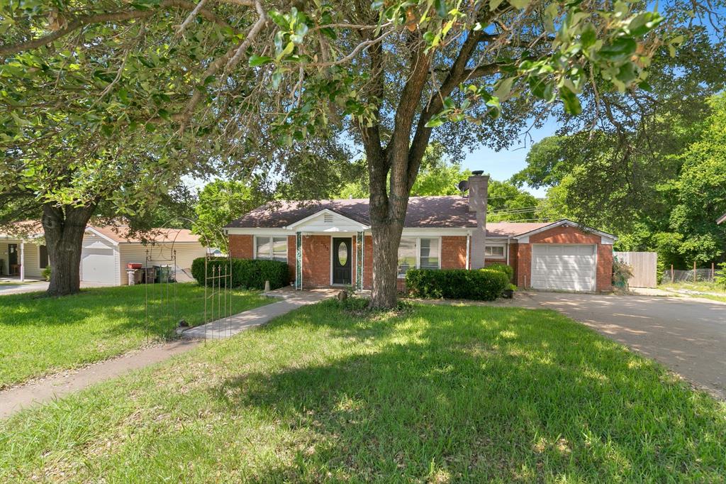 a front view of a house with a yard and trees