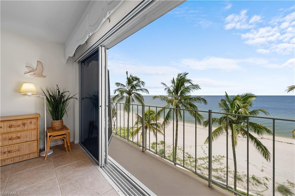 Balcony featuring a beach view and a water view