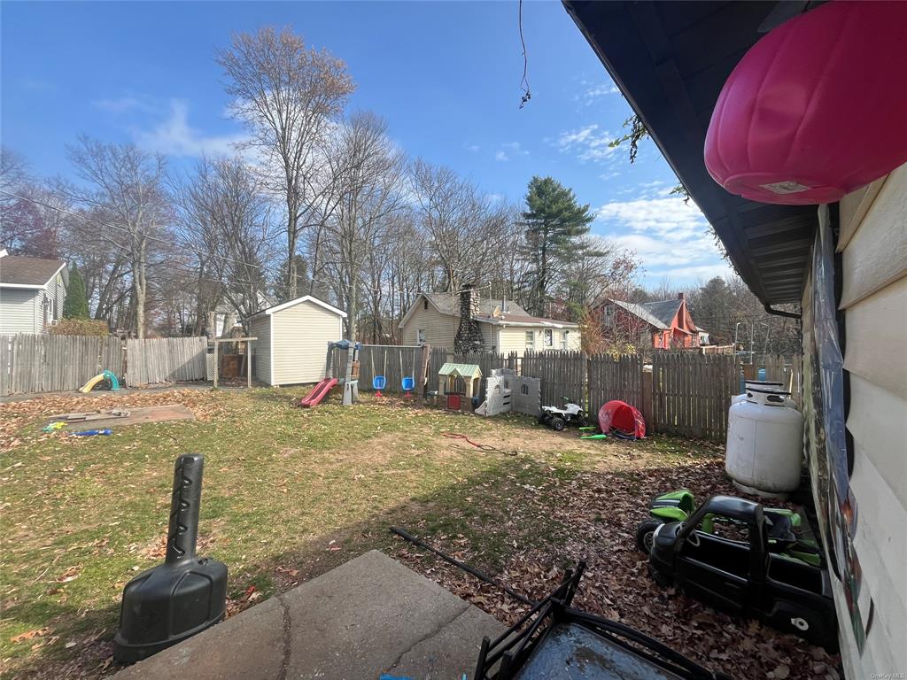 View of yard featuring a playground and a shed