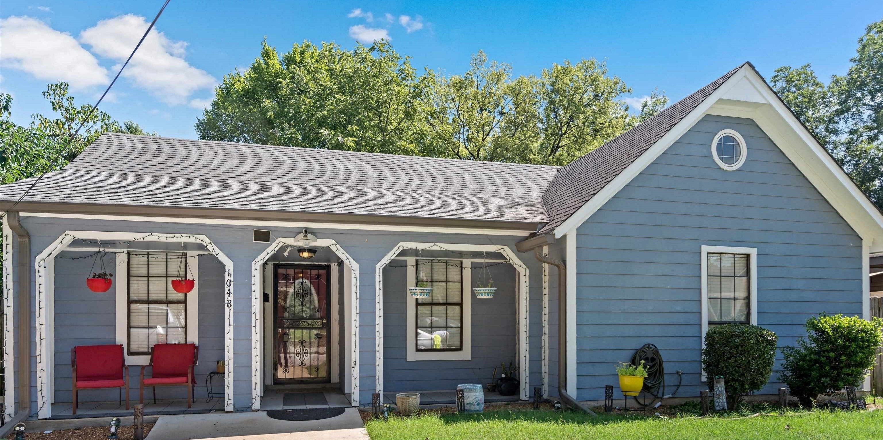 View of front of property with covered porch and a front yard