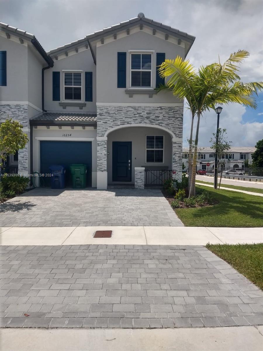 a front view of a house with a yard and a garage