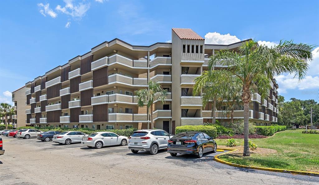 a front view of a building with cars parked