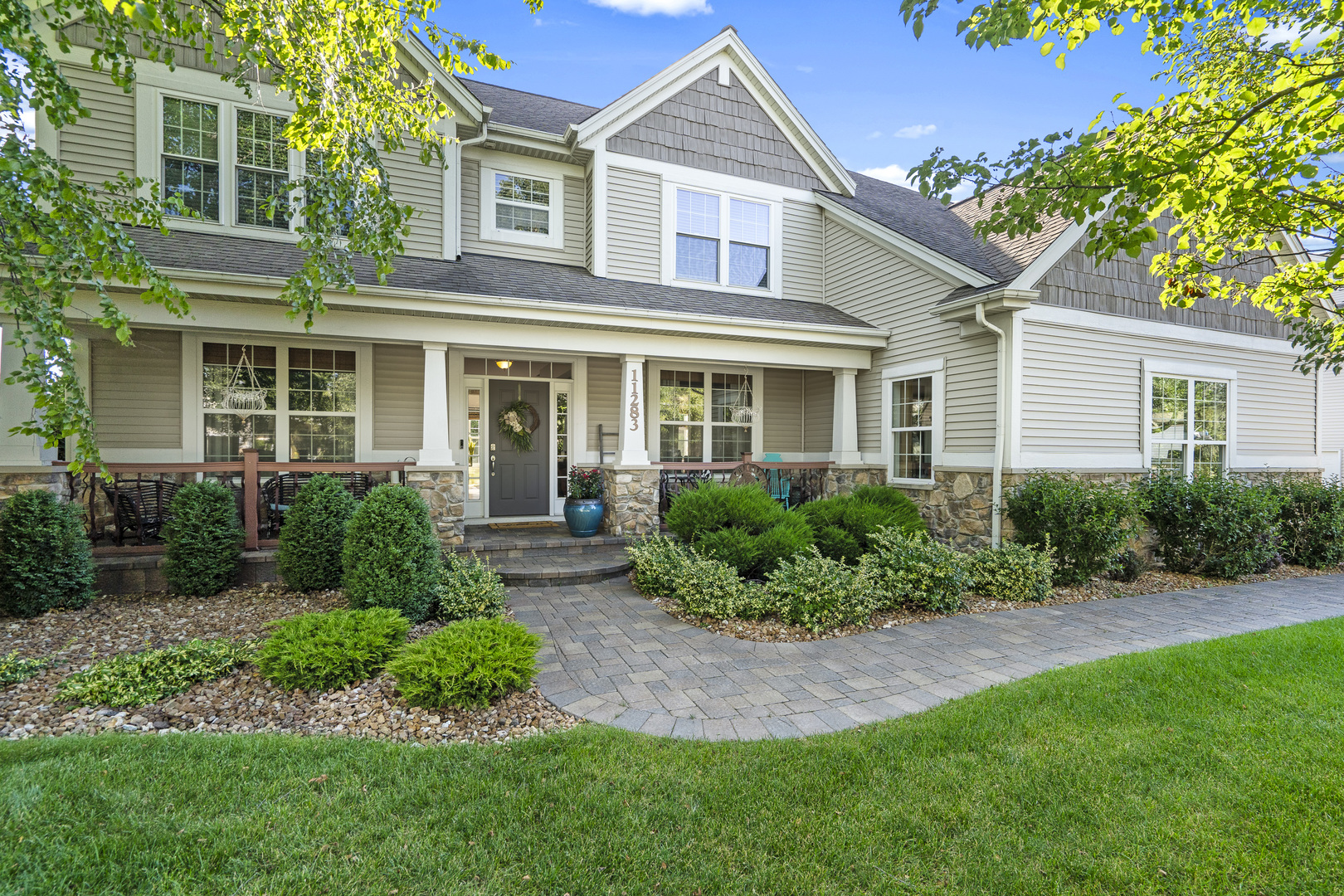 a front view of a house with a yard and potted plants