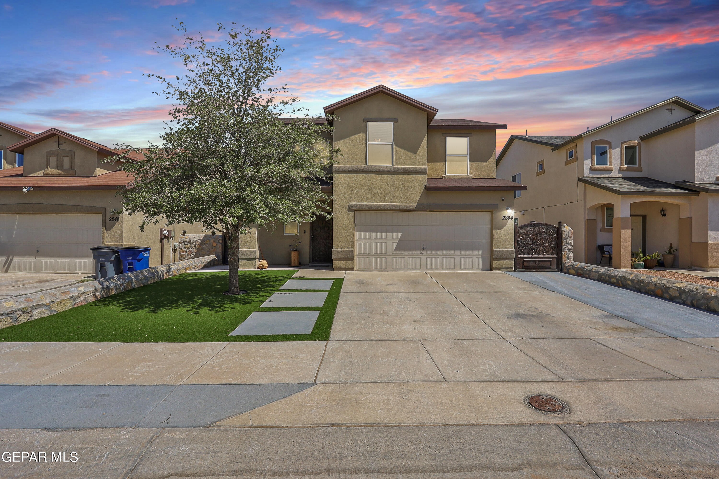 a front view of a house with a yard and a garage