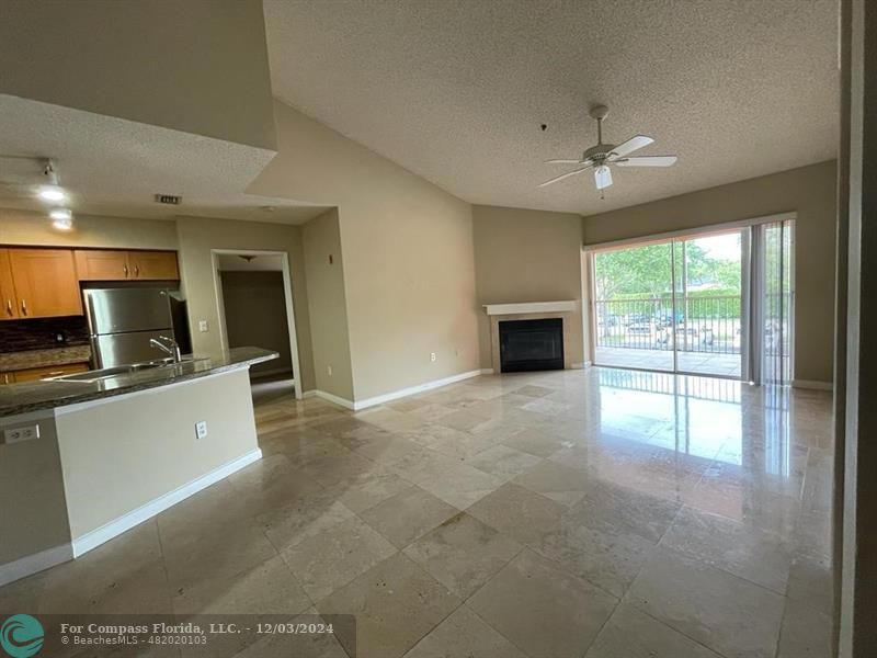 a view of a kitchen with an empty space and a fireplace