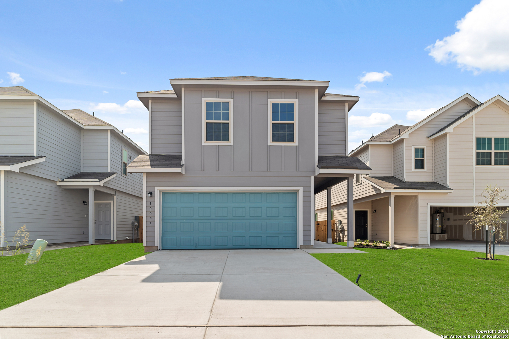 a front view of a house with a yard and a garage