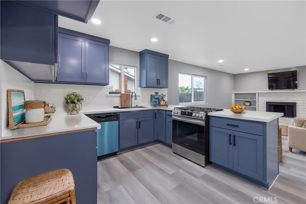 a kitchen with granite countertop a sink cabinets stainless steel appliances and a window