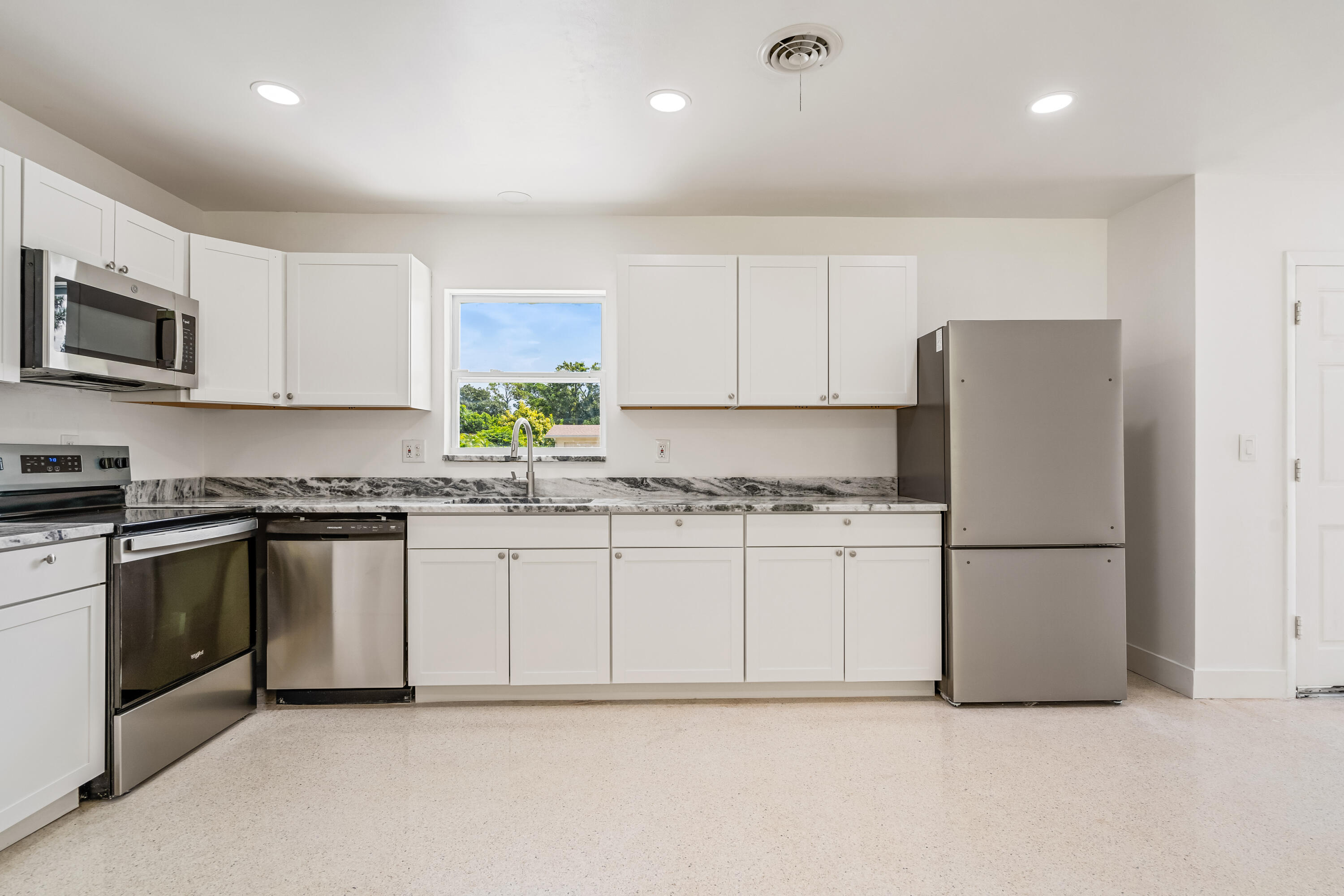 a kitchen with granite countertop white cabinets and white appliances