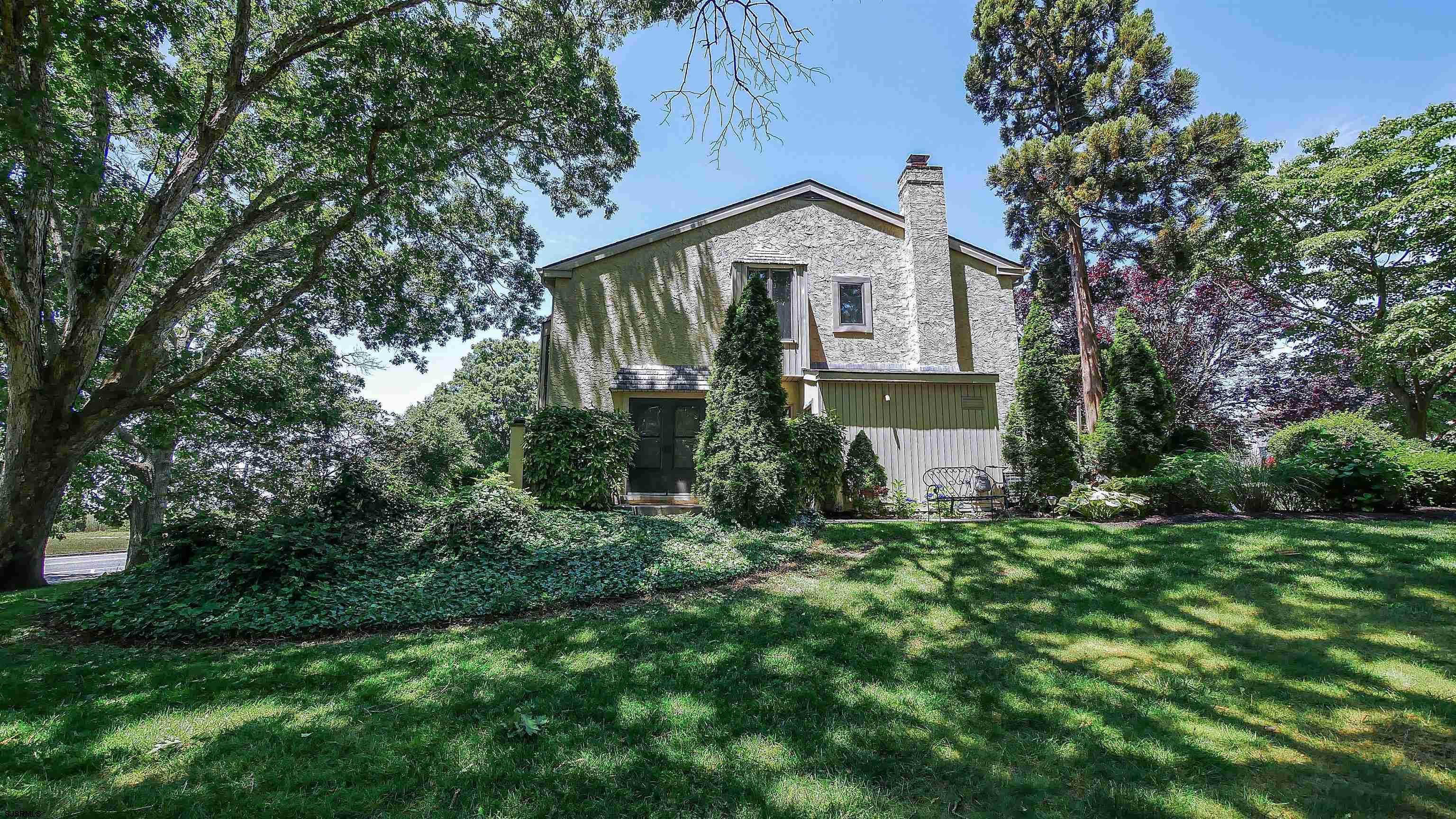 a view of a house with a small yard and a tree