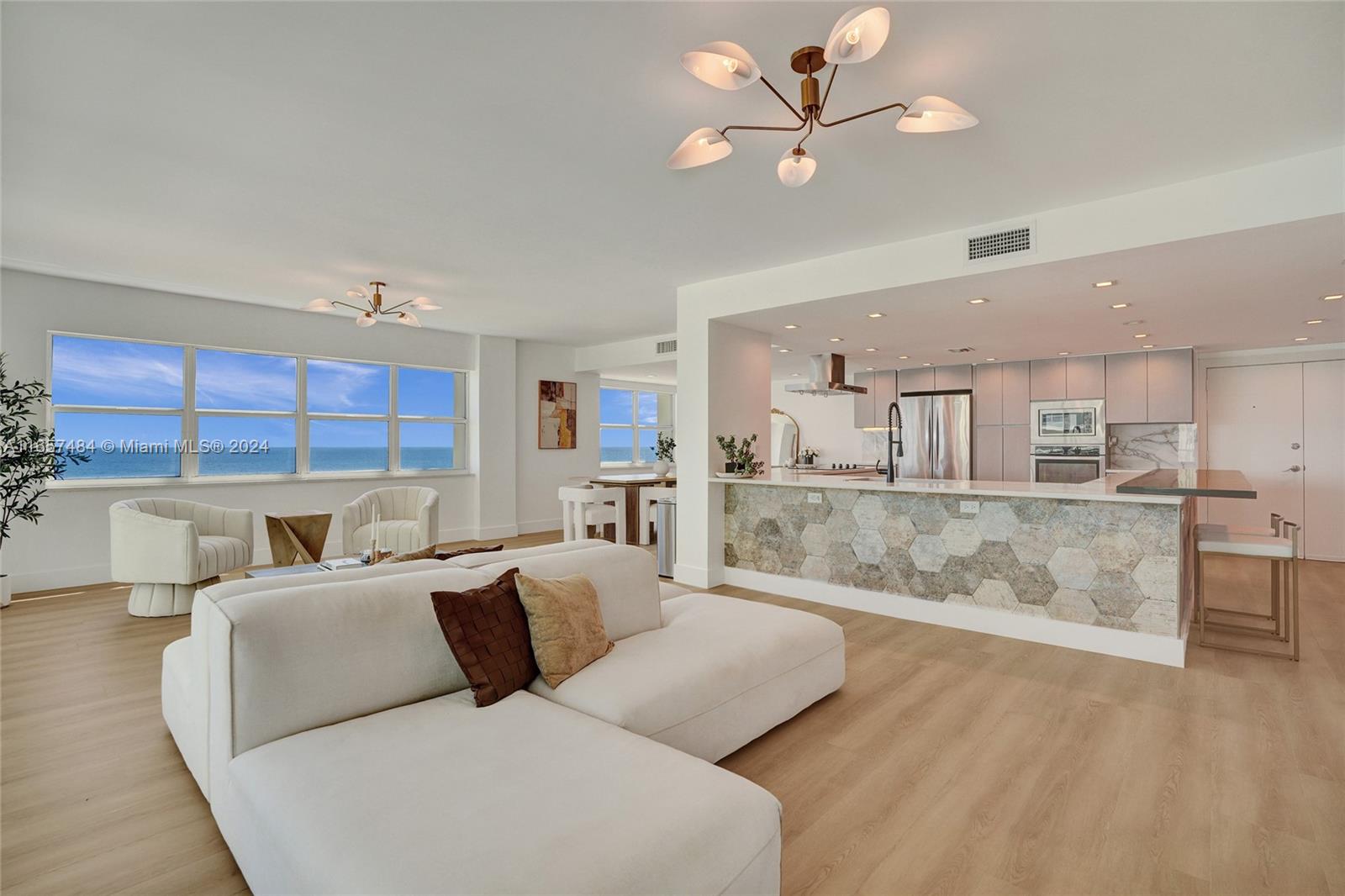 a living room with furniture kitchen view and a chandelier