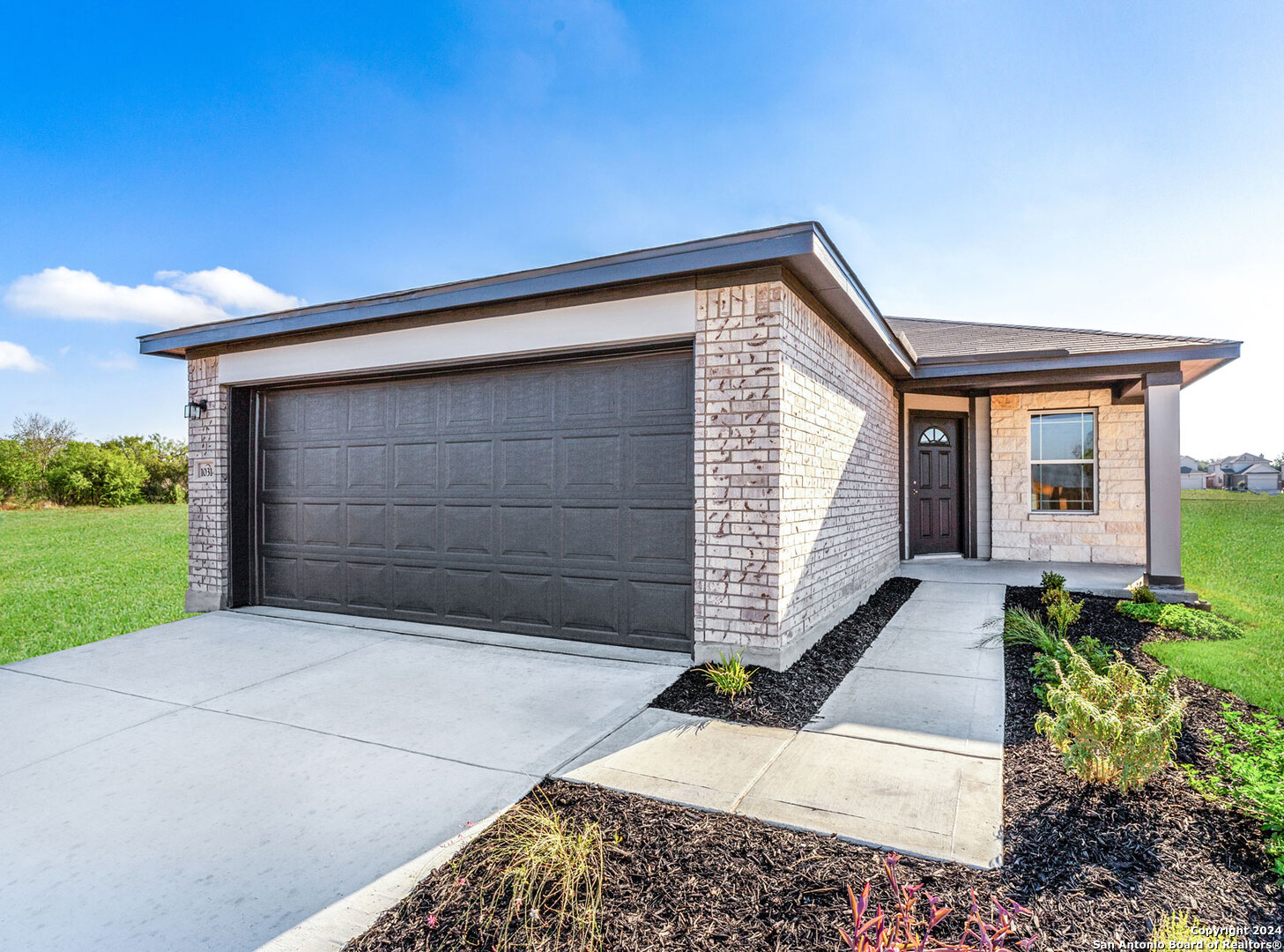 a front view of a house with a yard and garage