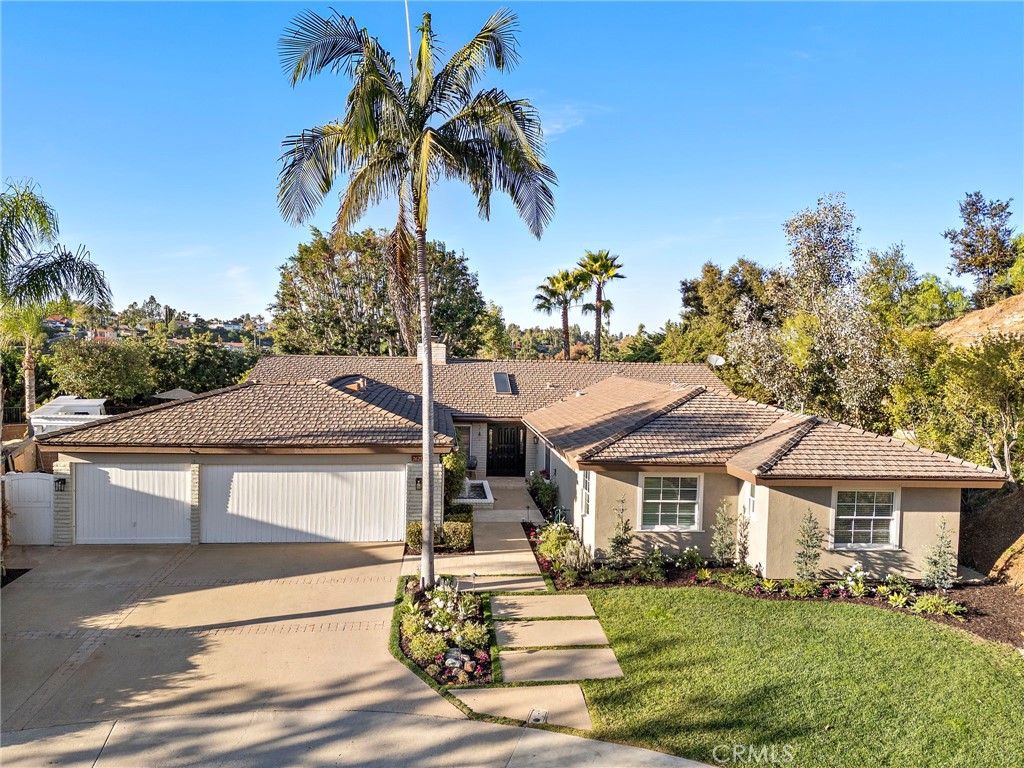 a front view of a house with a yard and potted plants