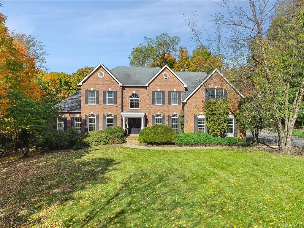 a view of a big house with a big yard and large trees