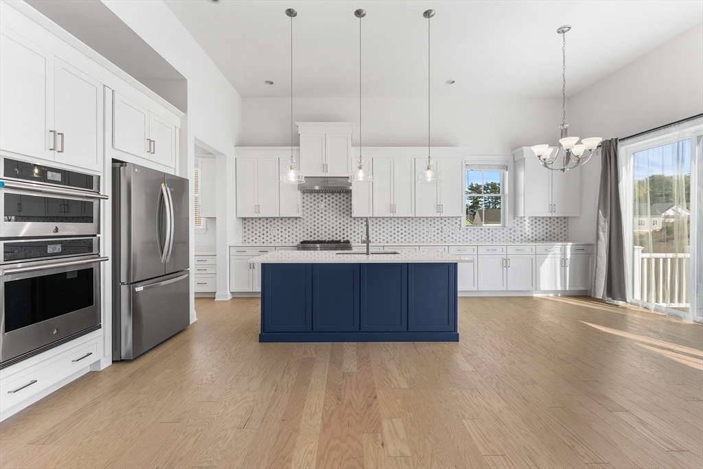 a kitchen with kitchen island a counter top space stainless steel appliances and cabinets