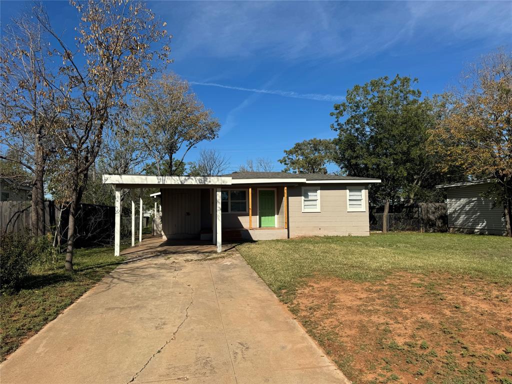 a front view of a house with yard and trees