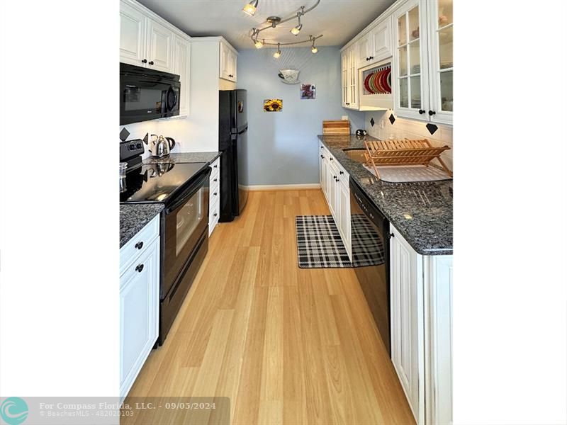 a kitchen with stainless steel appliances granite countertop a sink and a stove