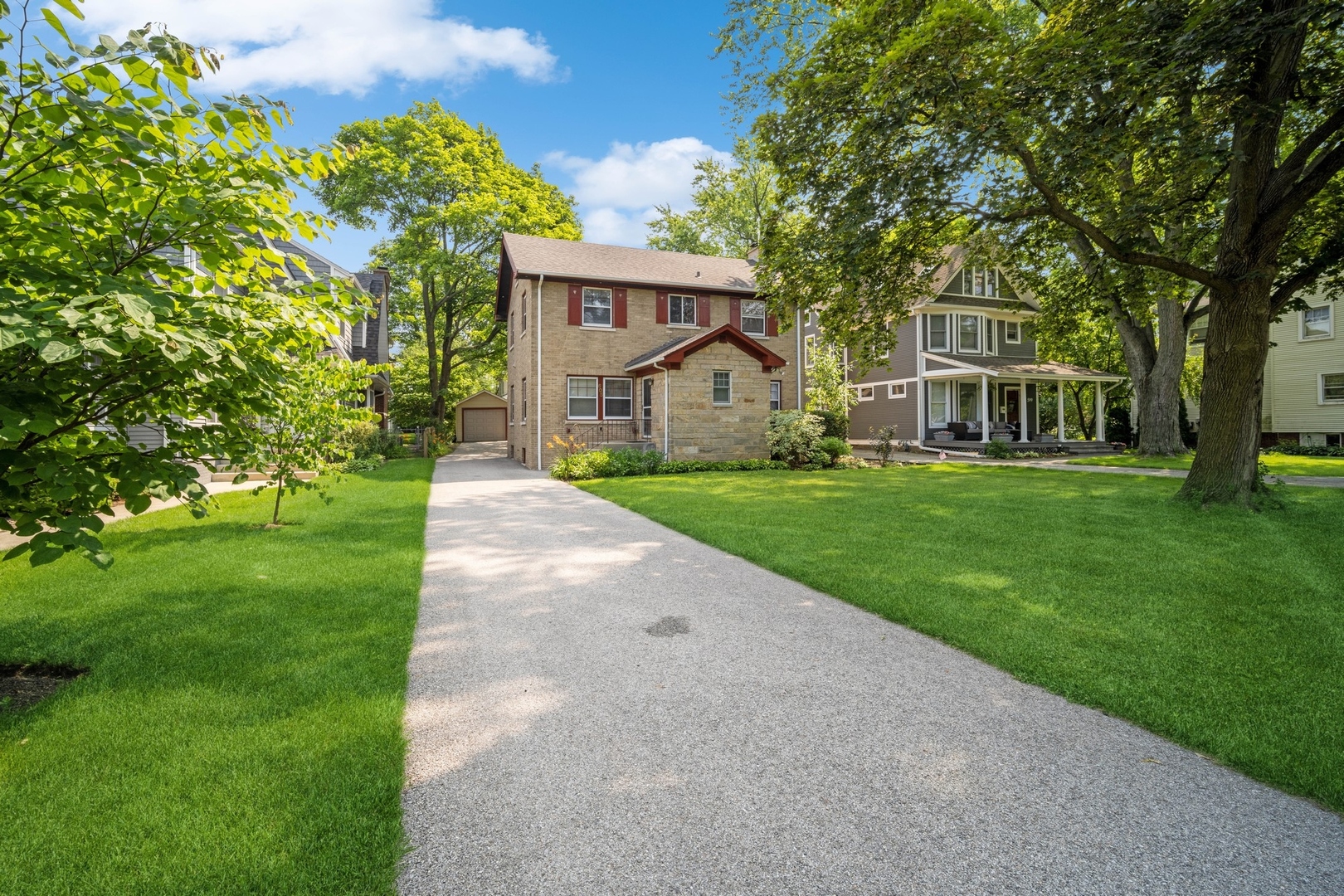 a front view of a house with a yard and trees