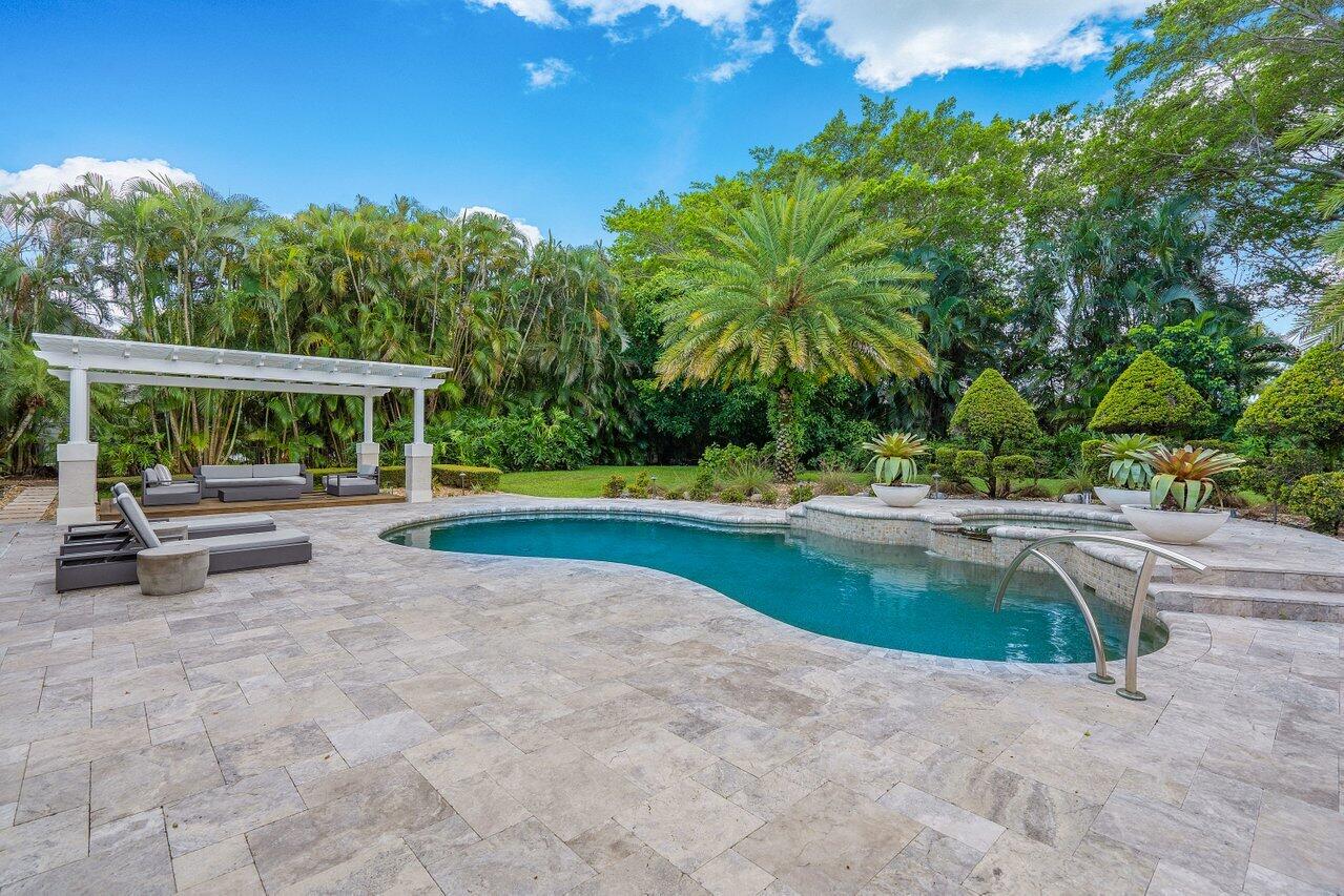 a view of swimming pool with sitting area and garden