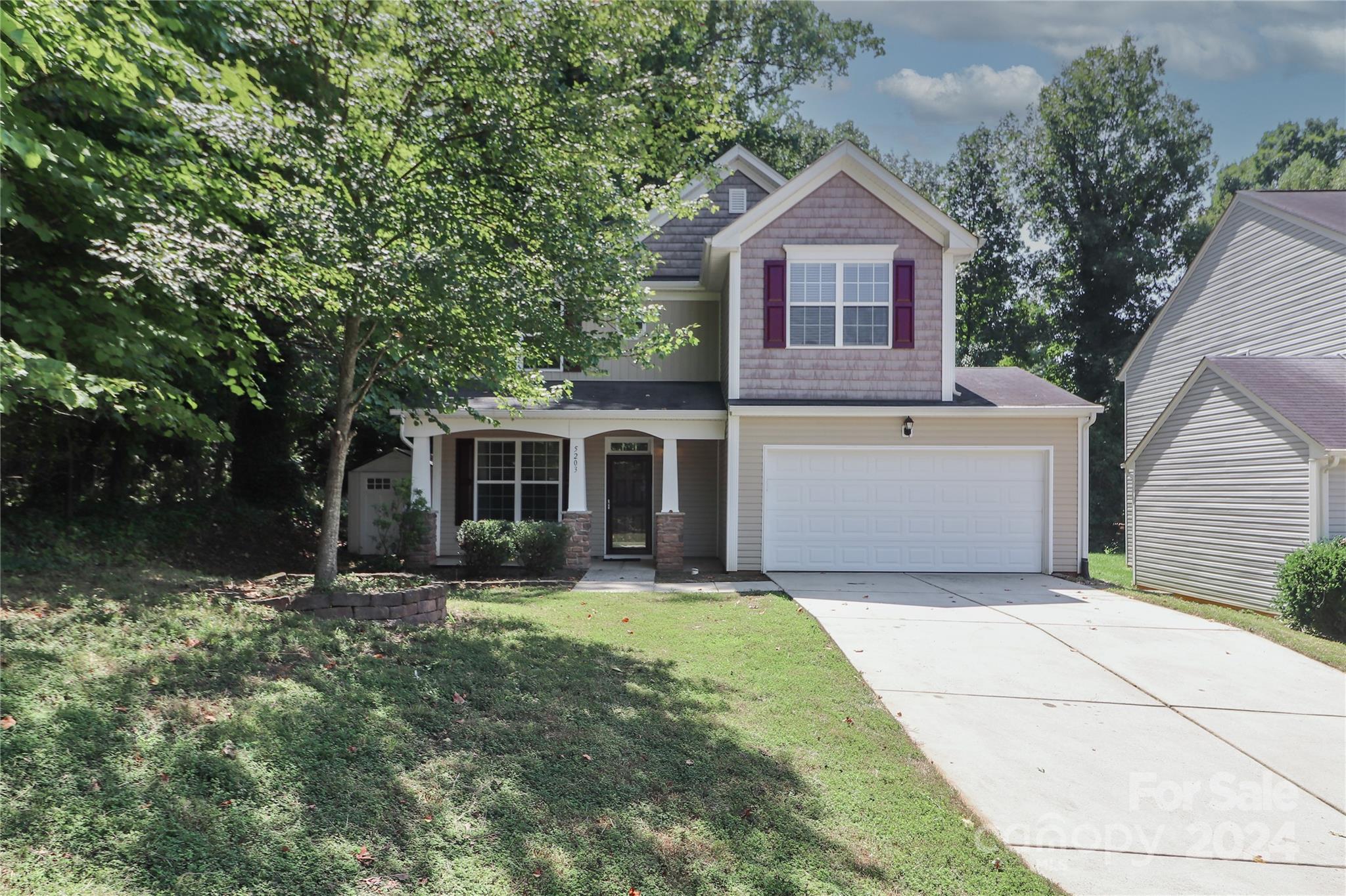 a front view of a house with yard and green space