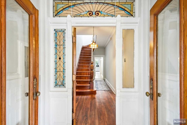 a view of a hallway with wooden floor and entryway