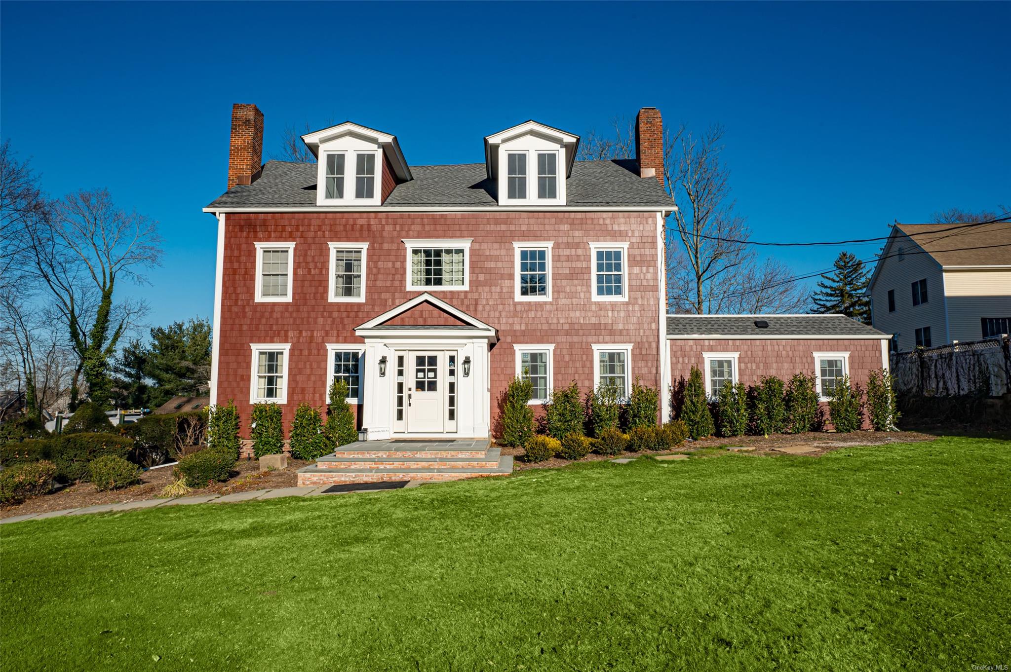 Colonial inspired home featuring a front lawn