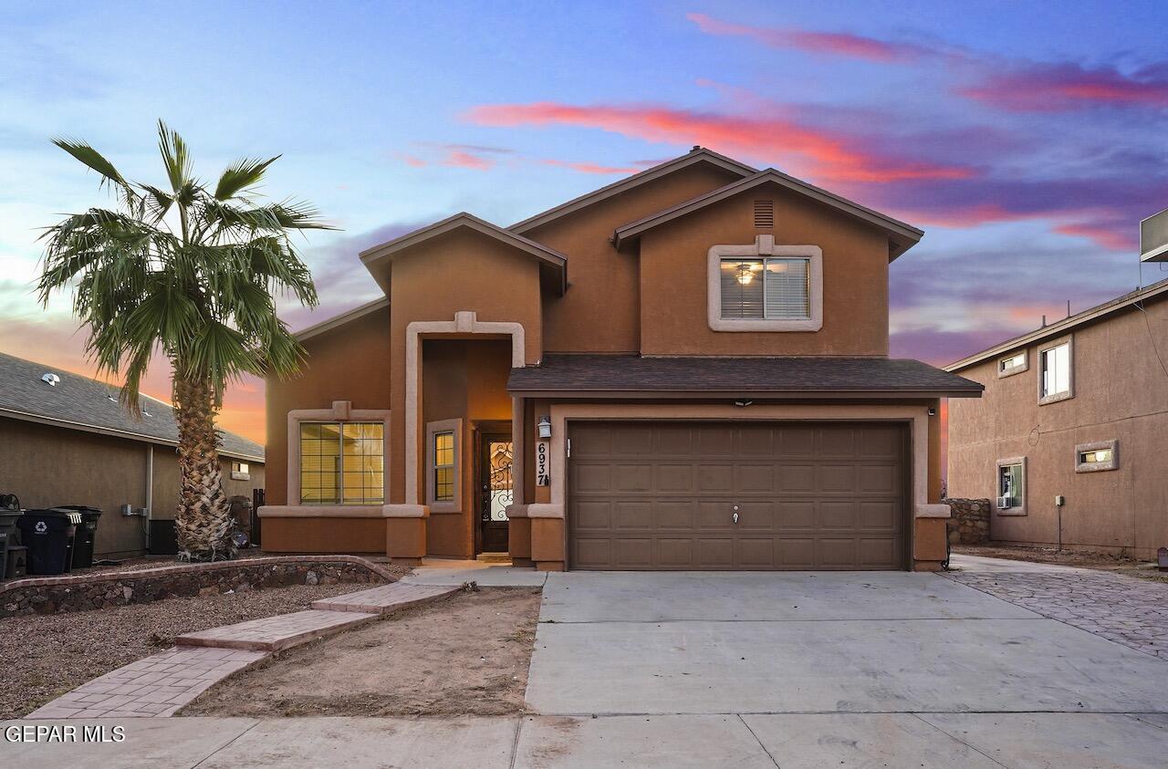 a front view of a house with a yard and garage