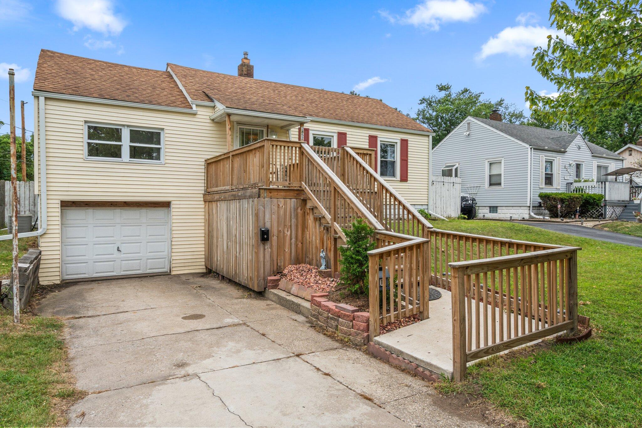 a view of house with small yard and deck