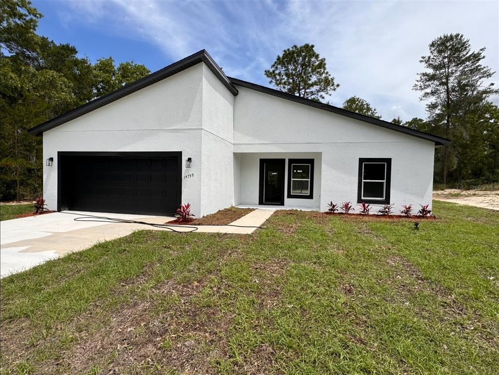 a view of a house with a yard and garage