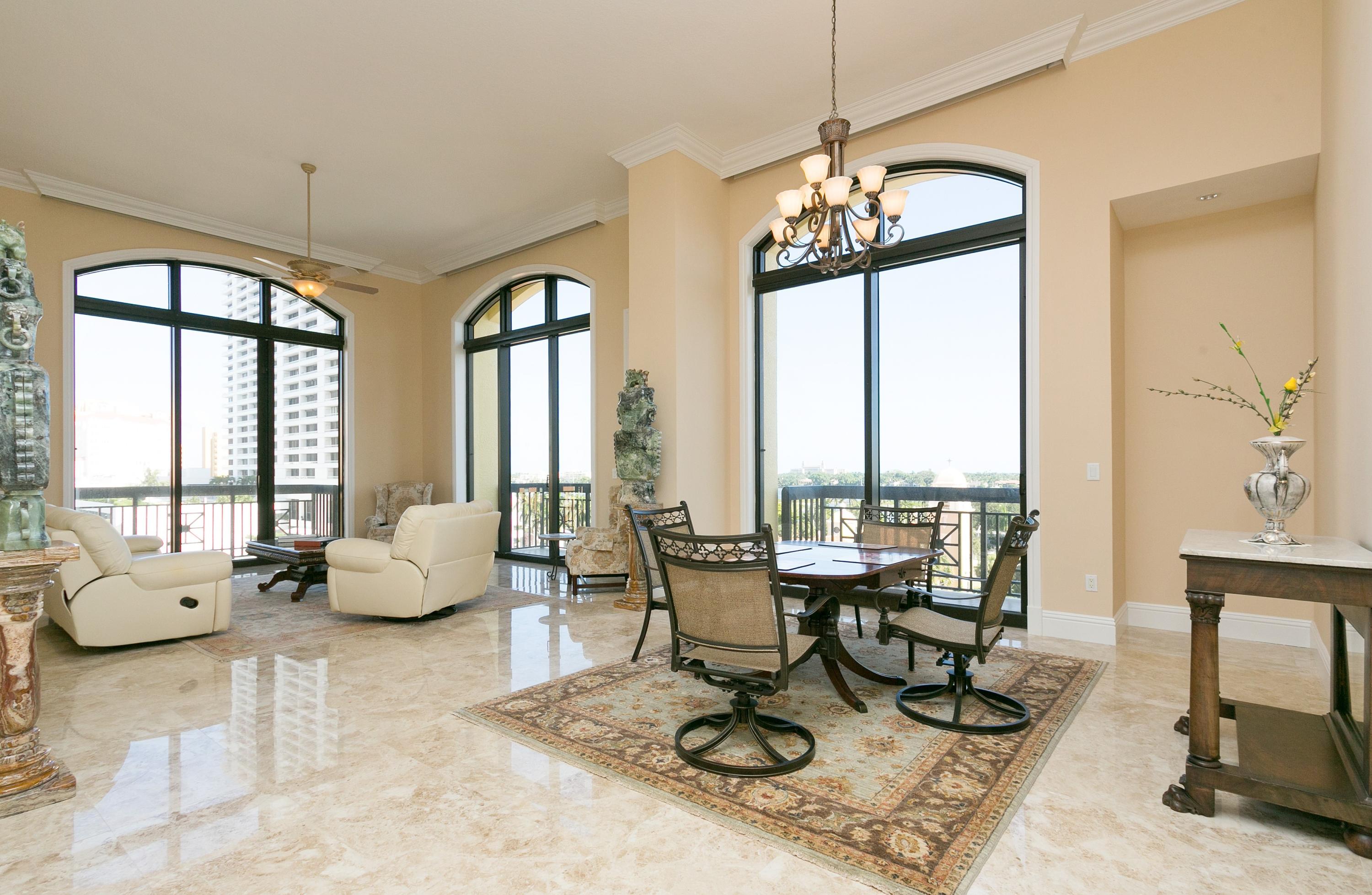 a living room with furniture and floor to ceiling windows