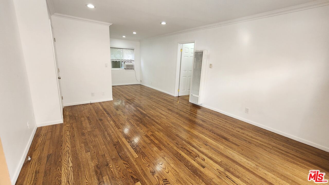 a view of empty room with wooden floor