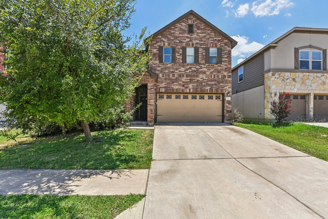 a front view of a house with a yard and garage