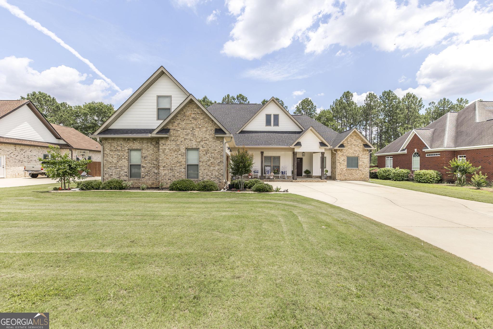 a front view of a house with a garden and yard