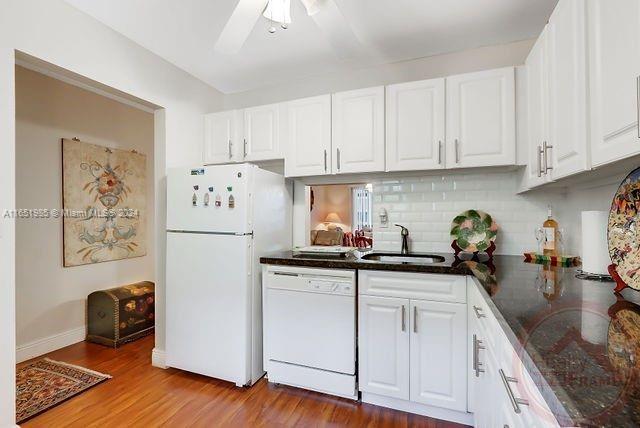 a kitchen with granite countertop white cabinets and white appliances